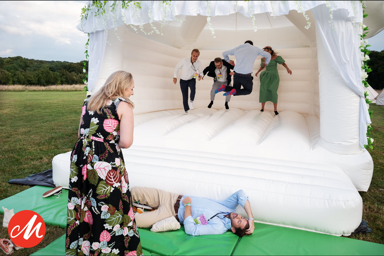 Wedding guests laughing and playing together on a bouncy castle