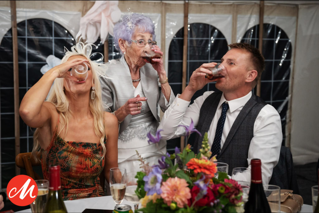 Three wedding guests enjoying Jägerbomb shots together