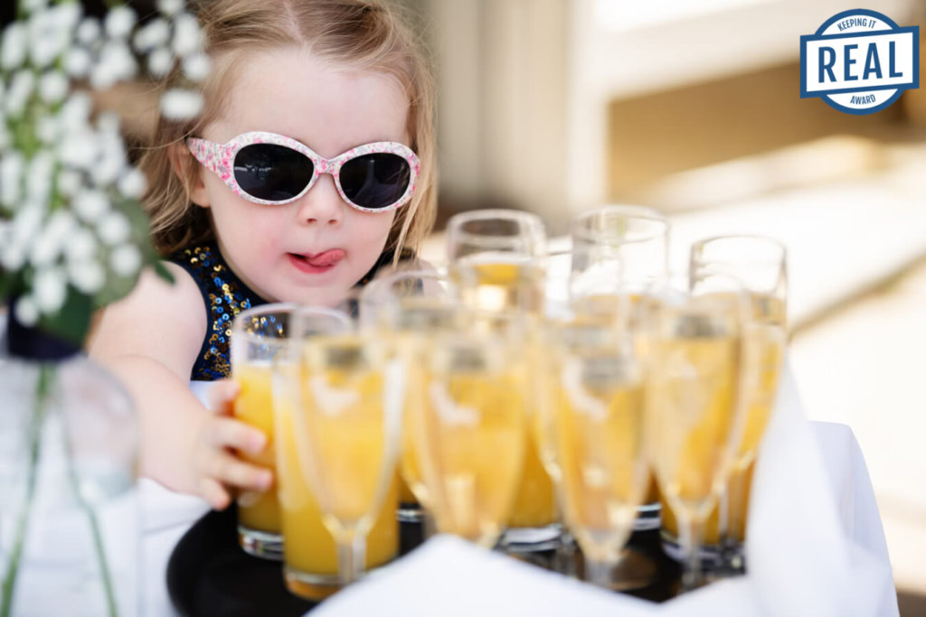 Young girl reaching for orange juice at a St Michael's Manor wedding